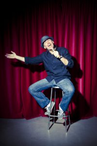 Mid adult comedian telling jokes.